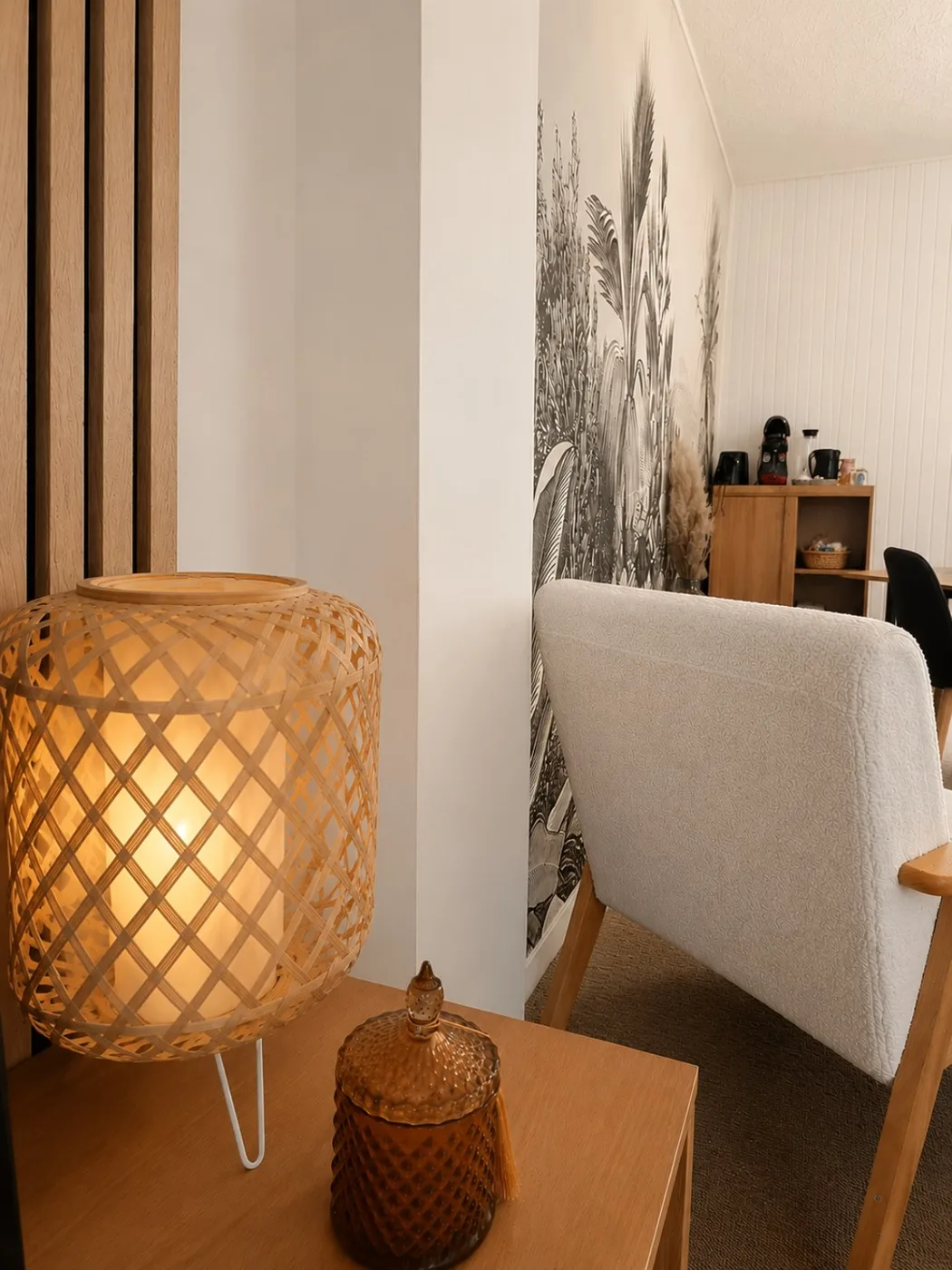 Coin lecture cosy avec lampe en osier et papier peint végétal à Rooms Home CSM
